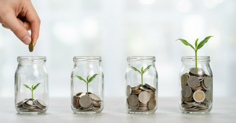 Miljoenenota 2027; 4 glazen potjes met stijgend muntgeld en een groeiend groen plantje